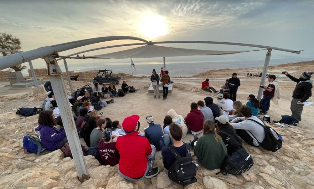 URJ Heller High Students gathered in a circle in a beautiful scenic mountaintop in Israel